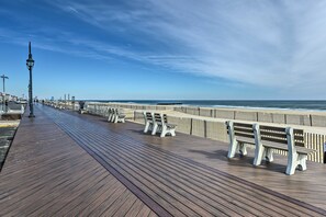 A spacious wooden boardwalk lined with benches overlooking the beach and ocean. - ‘The 1818’ - Quick walk to 20th Ave Beach! (Lake Como)