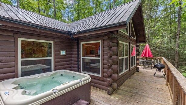 A cabin with a hot tub, deck, and outdoor seating area. - Cabin, Ensuite Bedrooms, Hot Tub, Firepit, Woods (Campton)