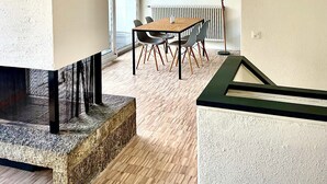 A modern interior with a wooden dining table, chairs, and a stone bench.