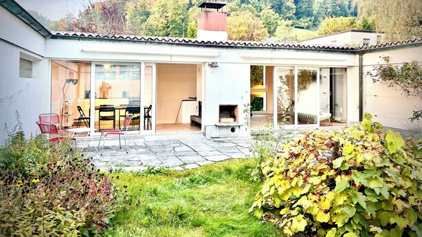 A modern house with a patio, a dining area, and a kitchen.