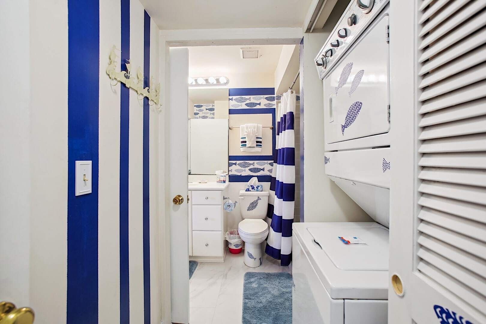 Ein schmales Badezimmer mit Toilette, Waschbecken und Duschbereich.