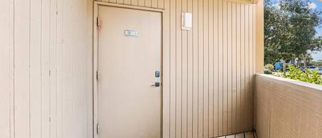 A beige door with a sign reading "E 202" and a keypad lock.