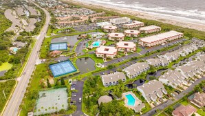 An aerial view of a coastal resort with multiple buildings, a beach, and a marina. - Serene St. Augustine Ocean & Racquet 8315 Getaway (St. Augustine)
