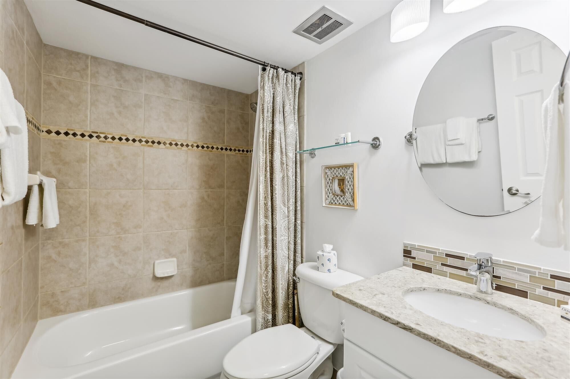 A bathroom with a bathtub, toilet, and sink.