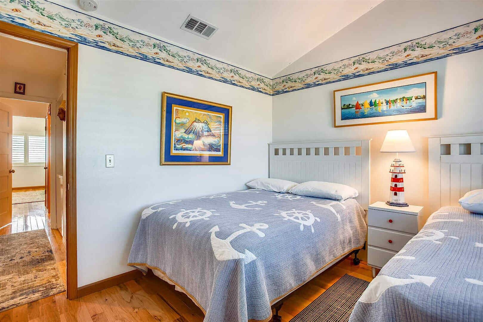 Una camera da letto con un letto, un comodino, una lampada e due quadri.