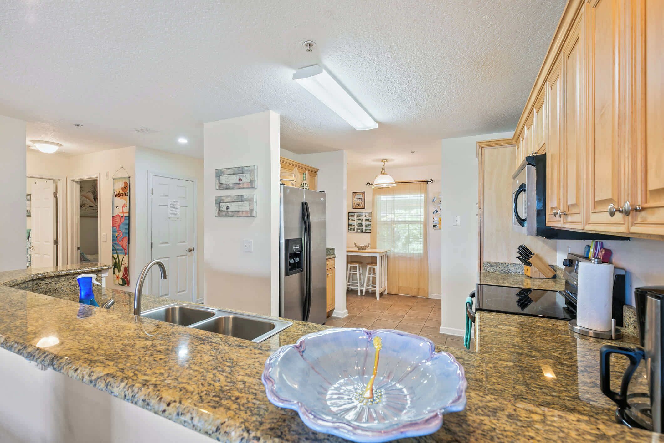 Una cocina con encimeras de granito, electrodomésticos de acero inoxidable y armarios de madera.