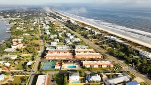 Vista aérea de una zona residencial costera con casas, una playa y un puerto deportivo.