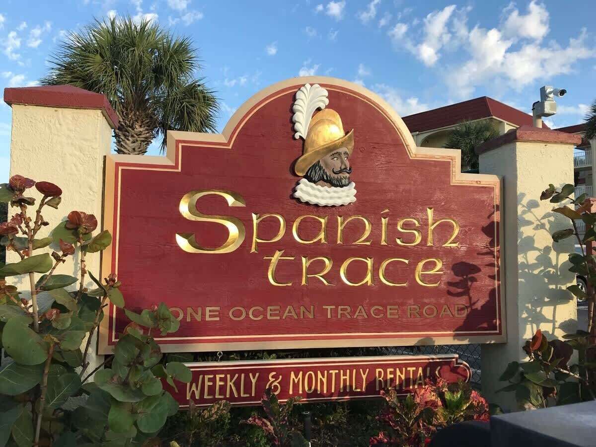 A sign for Spanish Trace, indicating weekly and monthly rentals.