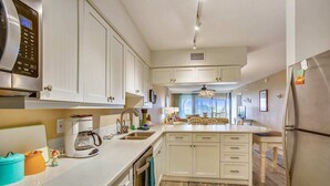 A modern kitchen with white cabinets, stainless steel appliances, and a central island. - Beachfront Bliss: St. Augustine Escape (St. Augustine)