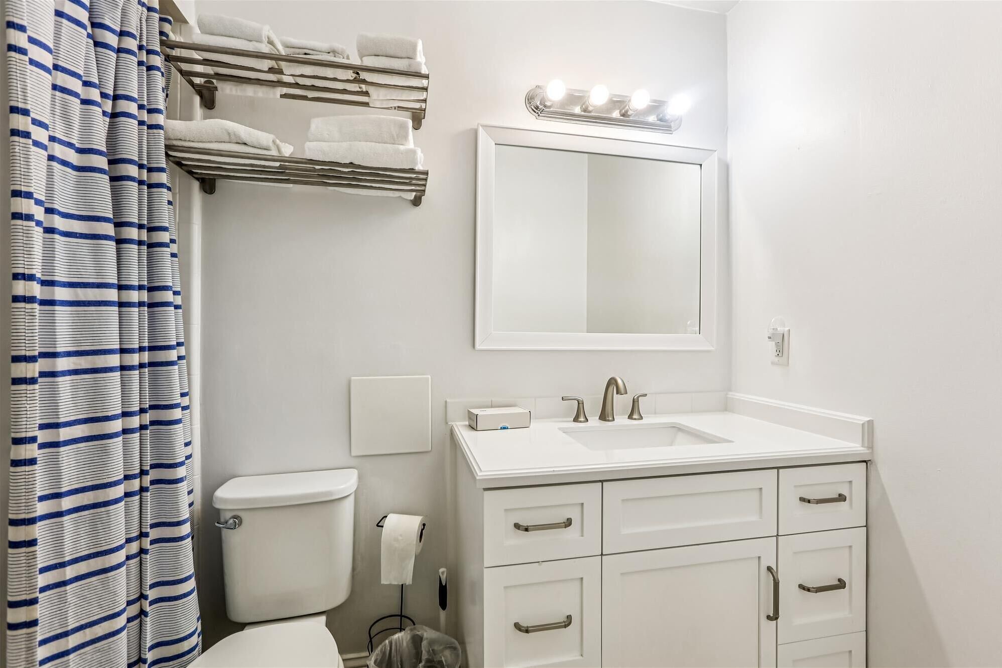 A bathroom with a white sink, a mirror, and a towel rack.
