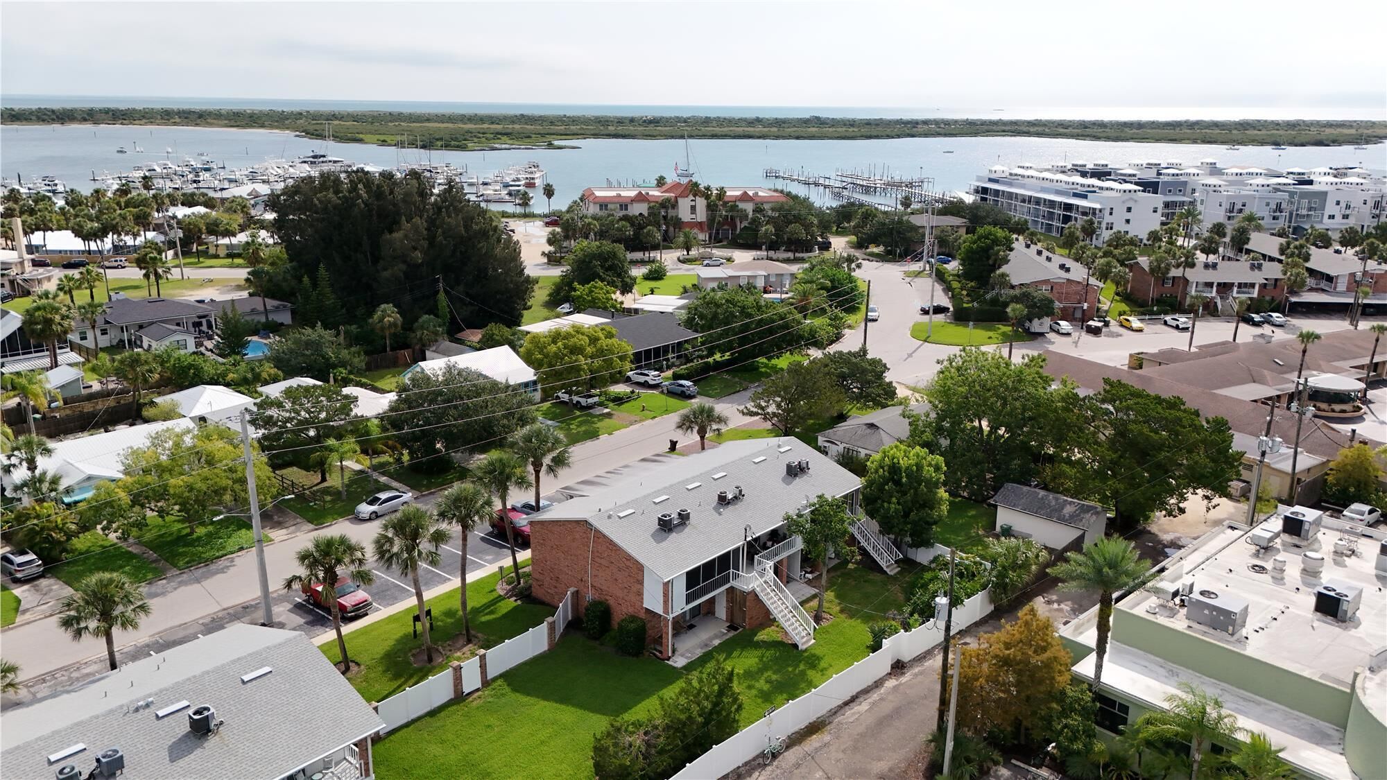 Vista aérea de una zona residencial con un edificio destacado que tiene techo plano y una escalera que lleva a un balcón.