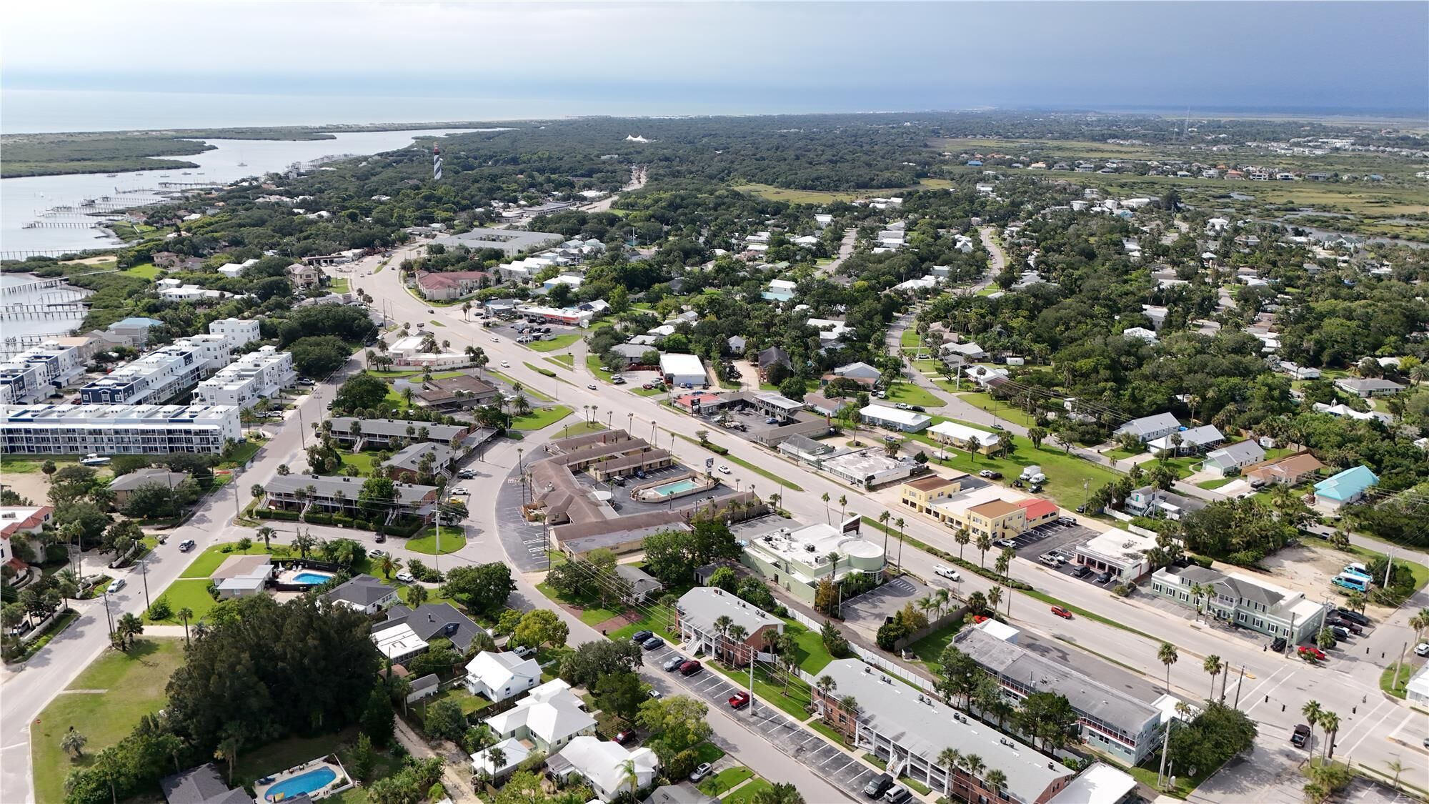 A coastal town with a mix of residential and commercial buildings, a prominent bridge, and a marina.
