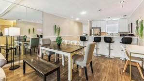 A modern kitchen with white cabinets, a stainless steel refrigerator, and a microwave.