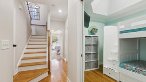 A staircase leading to a room with a bunk bed, storage cabinets, and a globe decoration.