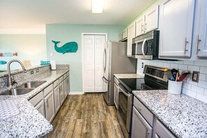 Condo, várias camas, banheira de imersão, vista para o oceano (Ocean Gate I301) | Cozinha privada | Geladeira, micro-ondas, fogão, cooktop