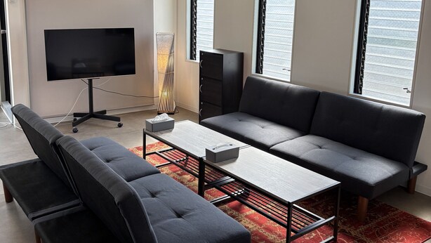 Ein modernes Wohnzimmer mit einer Couch, einem Couchtisch und einem Fernseher.