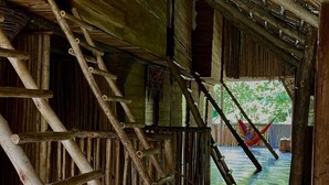 A rustic wooden staircase leading to a covered outdoor area with a hammock. - Ganesh Hostel (El Valle)