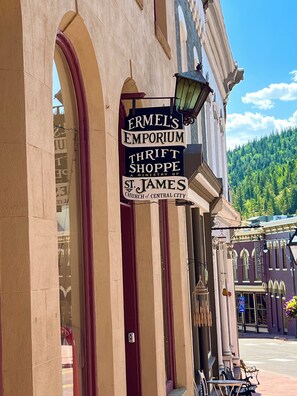 A building with a sign for 'Ermel's Emporium Thrift Shoppe' and 'St. James Church of Central City'.