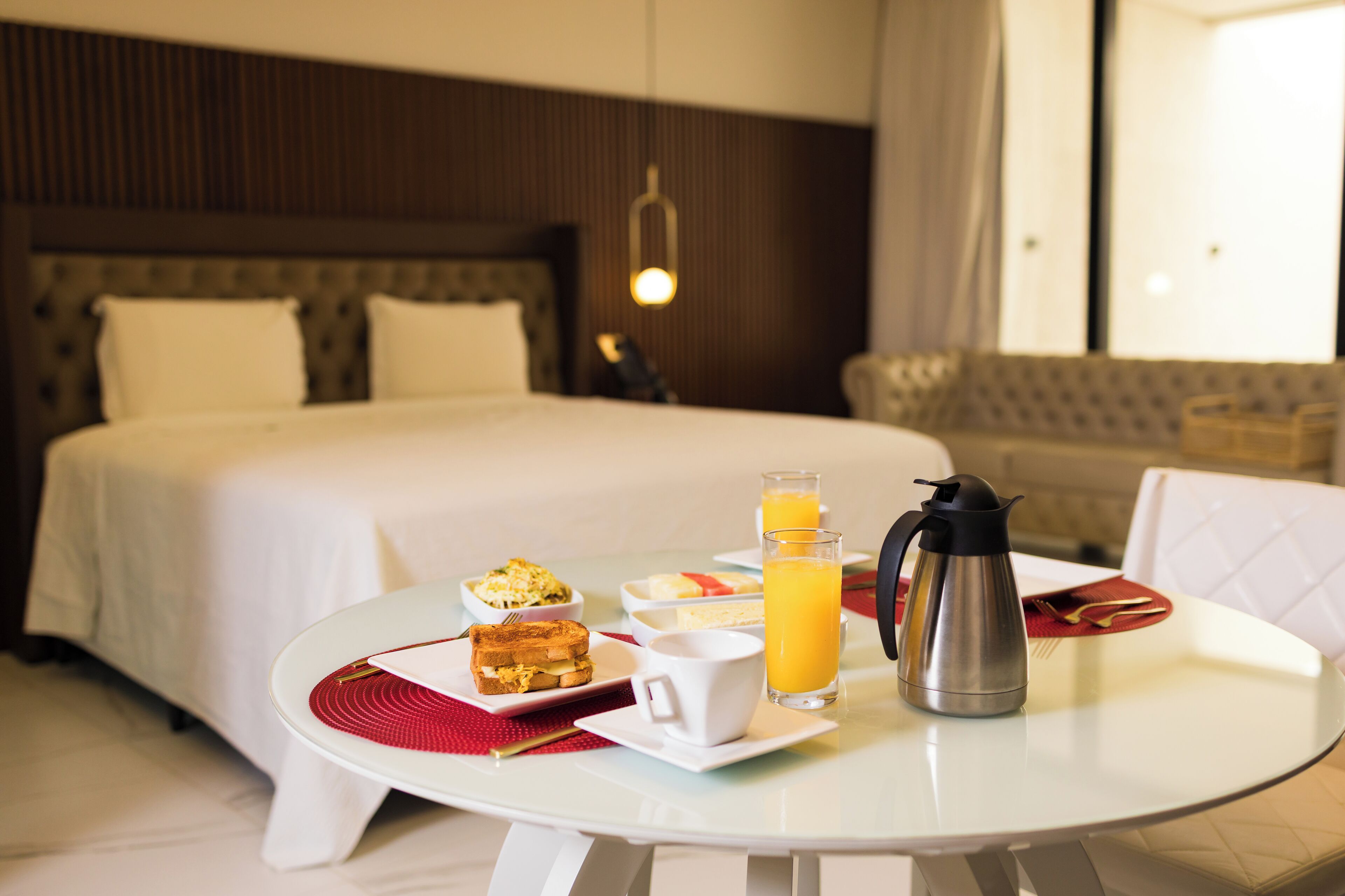 A neatly arranged breakfast table with toast, eggs, and orange juice in a hotel room.