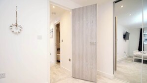 Una habitación moderna con puerta corredera, espejo y cama.