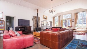 A spacious living room with a large sectional sofa, a television, and a stone fireplace.