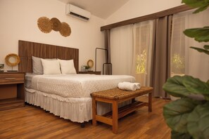 A bedroom with a wooden bed, a bedside table, a bench, and a large window with curtains. - The Rooftop Hotel Beach & Club (La Libertad)
