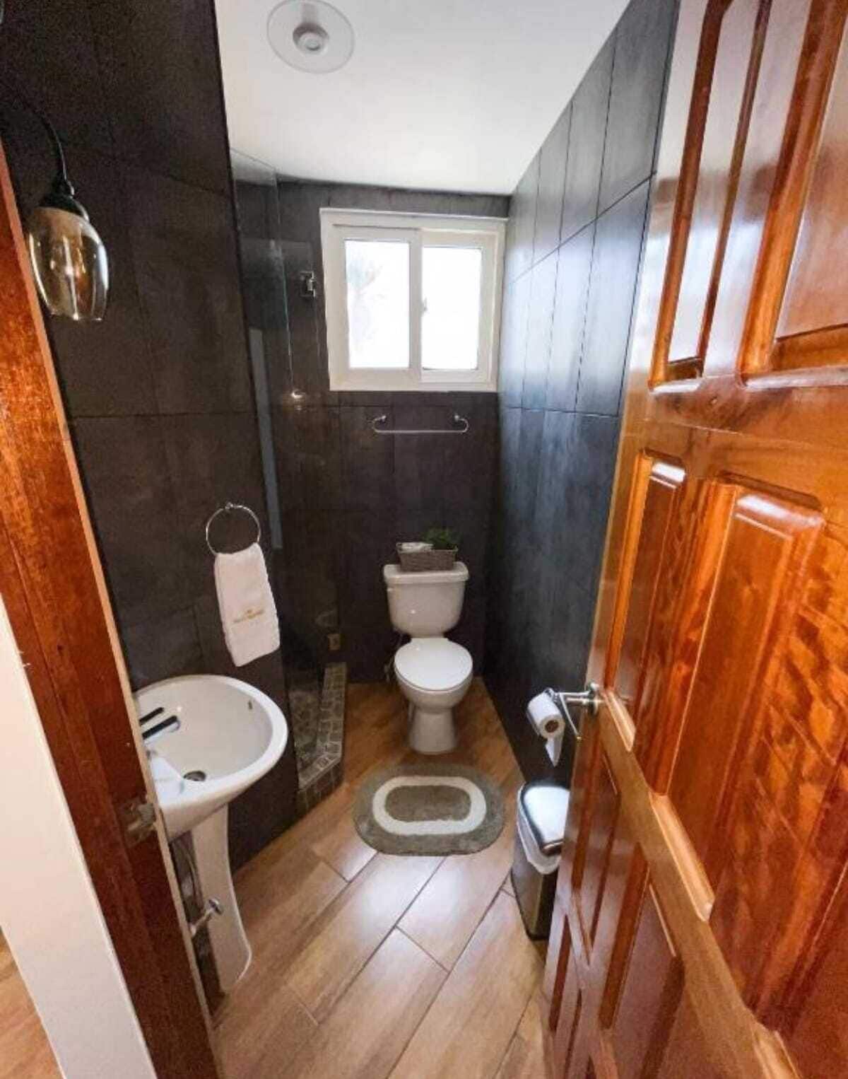 A compact bathroom with a toilet, sink, and shower area.
