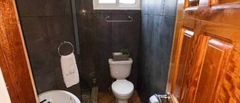 A compact bathroom with a toilet, sink, and shower area.