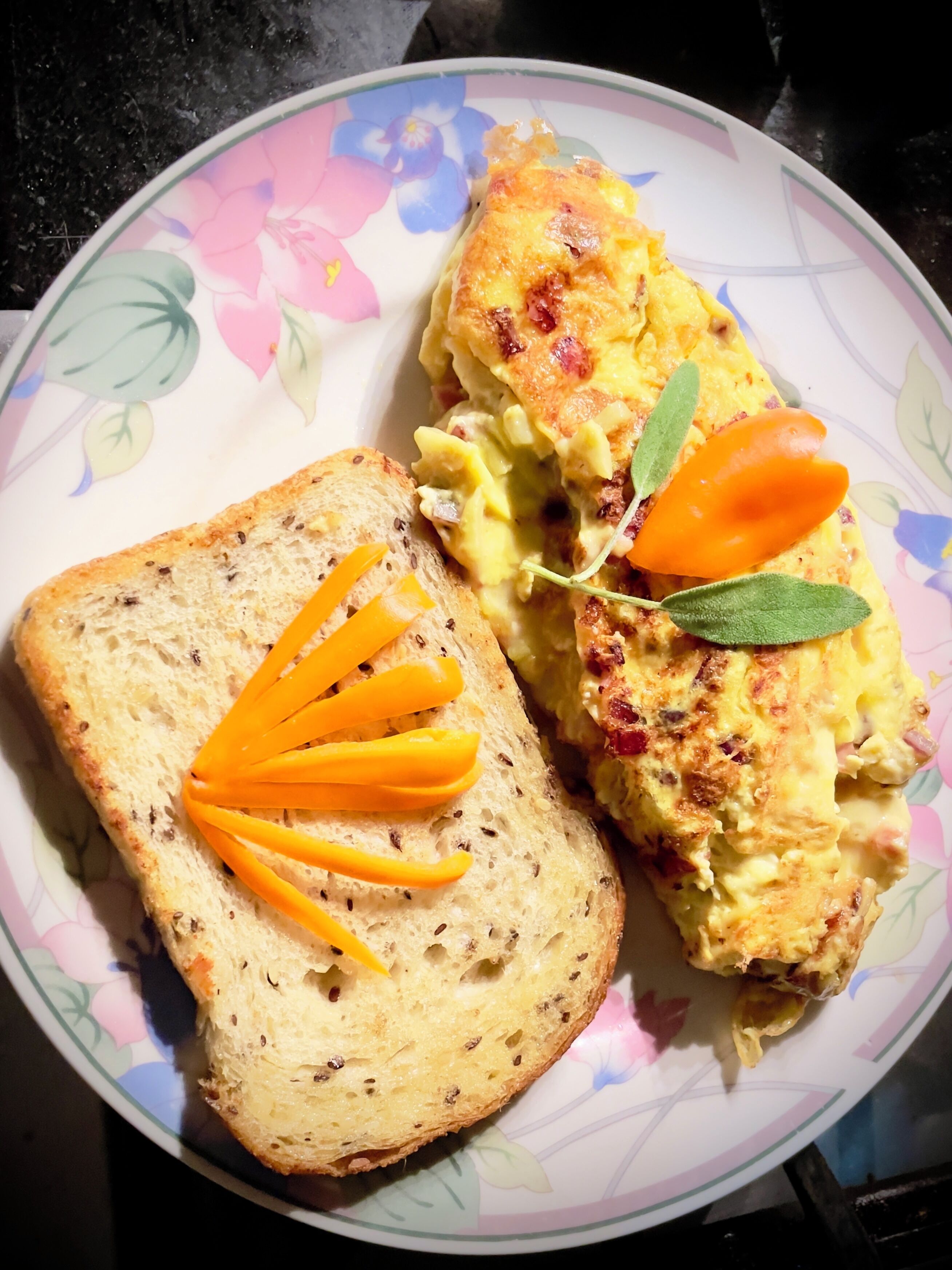 A plate with a slice of bread topped with cheese and a piece of scrambled eggs garnished with a carrot and a leaf.