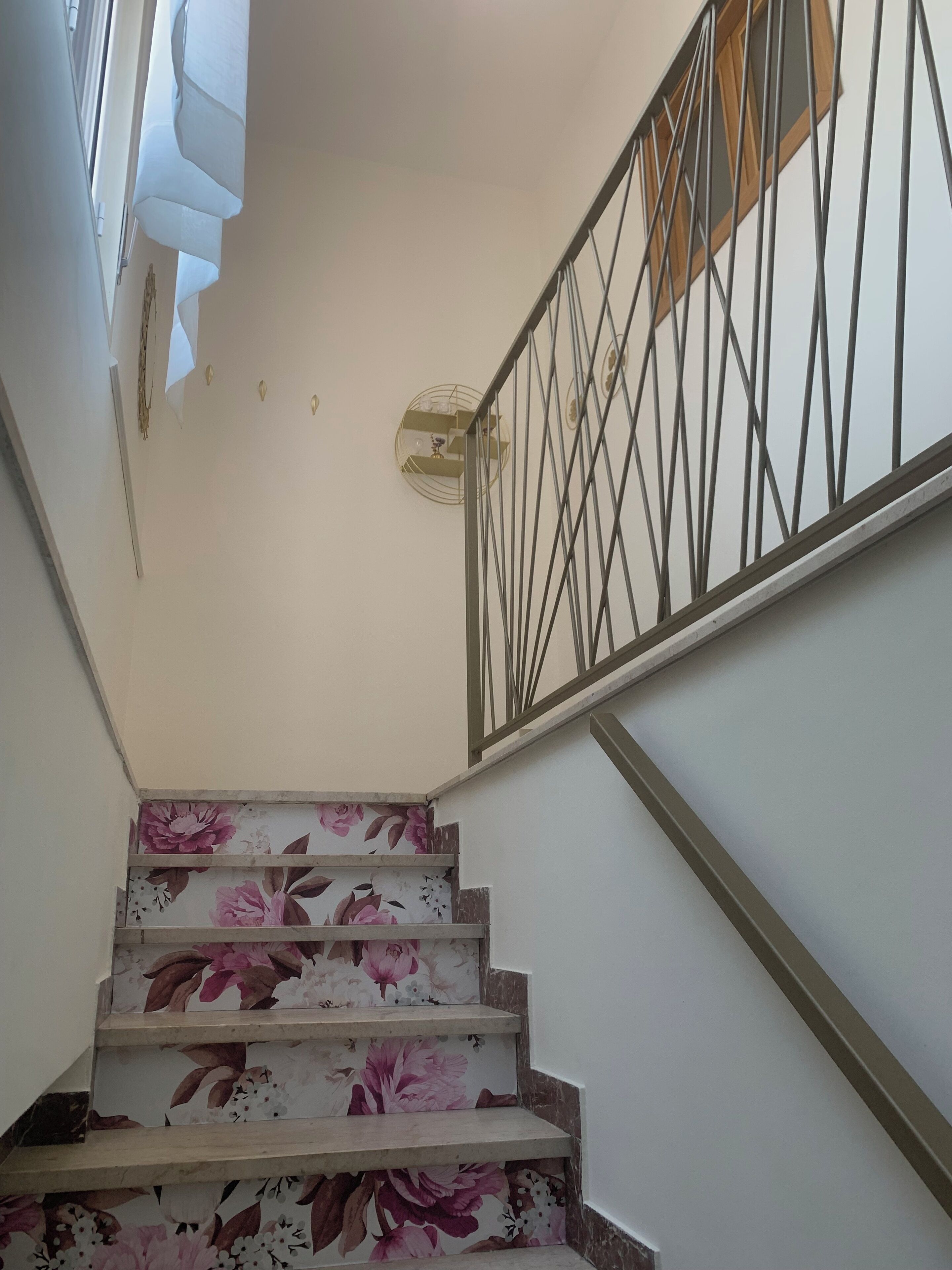 A staircase with floral-patterned steps and a metal railing.