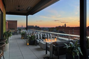 A rooftop terrace with outdoor seating, a fire feature, and a cityscape view. - AC Hotel Auburn (Auburn)