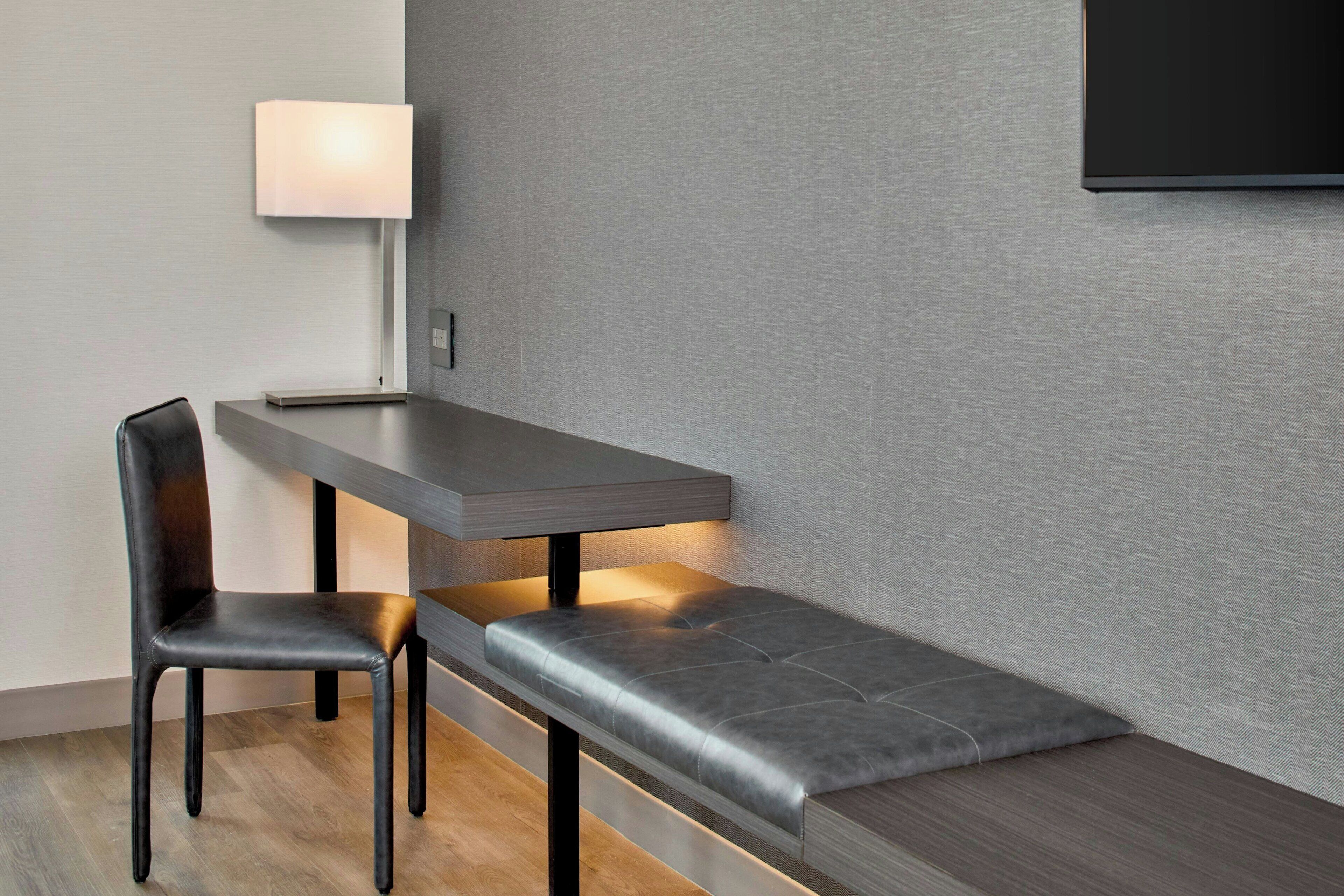 A modern dining area with a bench, a table, and a chair.