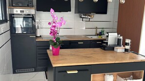A modern kitchen with black cabinetry, a wooden countertop, and a built-in oven. - L'échapée belle (Beinheim)