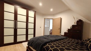 A bedroom with a bed, wooden wardrobe, and a dresser. - L'échapée belle (Beinheim)
