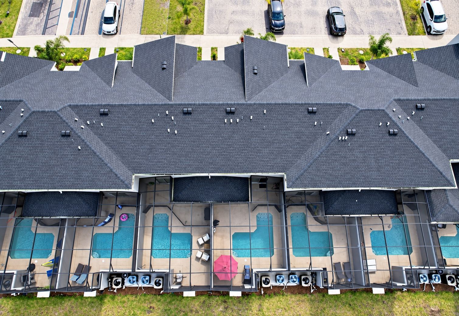 Et hotel med flere etager, en pool på taget, flere swimmingpools og en parkeringsplads.