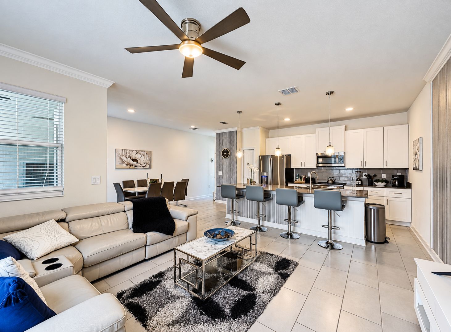 A modern living room with a sofa, coffee table, and a ceiling fan.