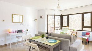 A modern living room with a dining area, a sofa, and a desk with a laptop. - Beautiful Views, Balcony, Downtown (Granada)