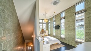 Une chambre spacieuse avec un grand lit, une coiffeuse et un lustre.