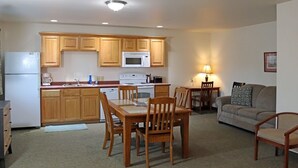 A compact living space with a kitchenette, dining area, and seating area. - Vision Inn Motel (Falls City)