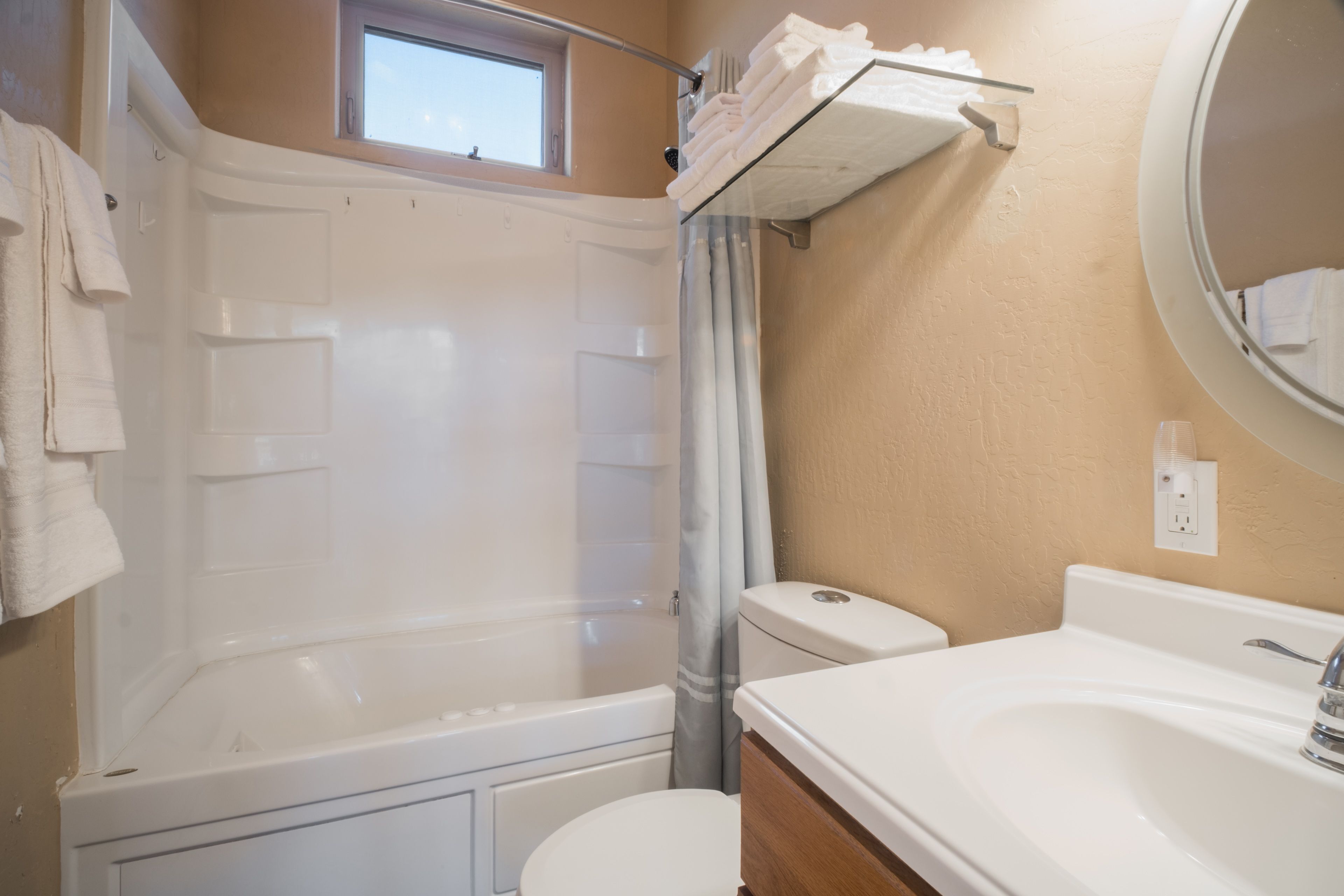 A bathroom with a bathtub, toilet, and sink.