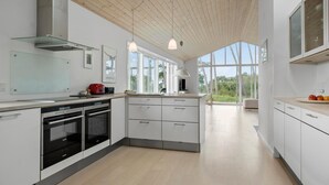 A modern kitchen with white cabinetry, a built-in oven, and a large window providing natural light. - Amazing home in Nykøbing Sj with WiFi (Nykøbing Sj)