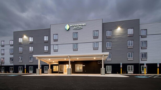 Un hotel de varios pisos con un diseño moderno, que cuenta con una entrada cubierta y múltiples ventanas en cada planta.
