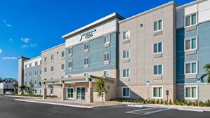 Un hotel moderno con techo plano, varias ventanas y una entrada cubierta.