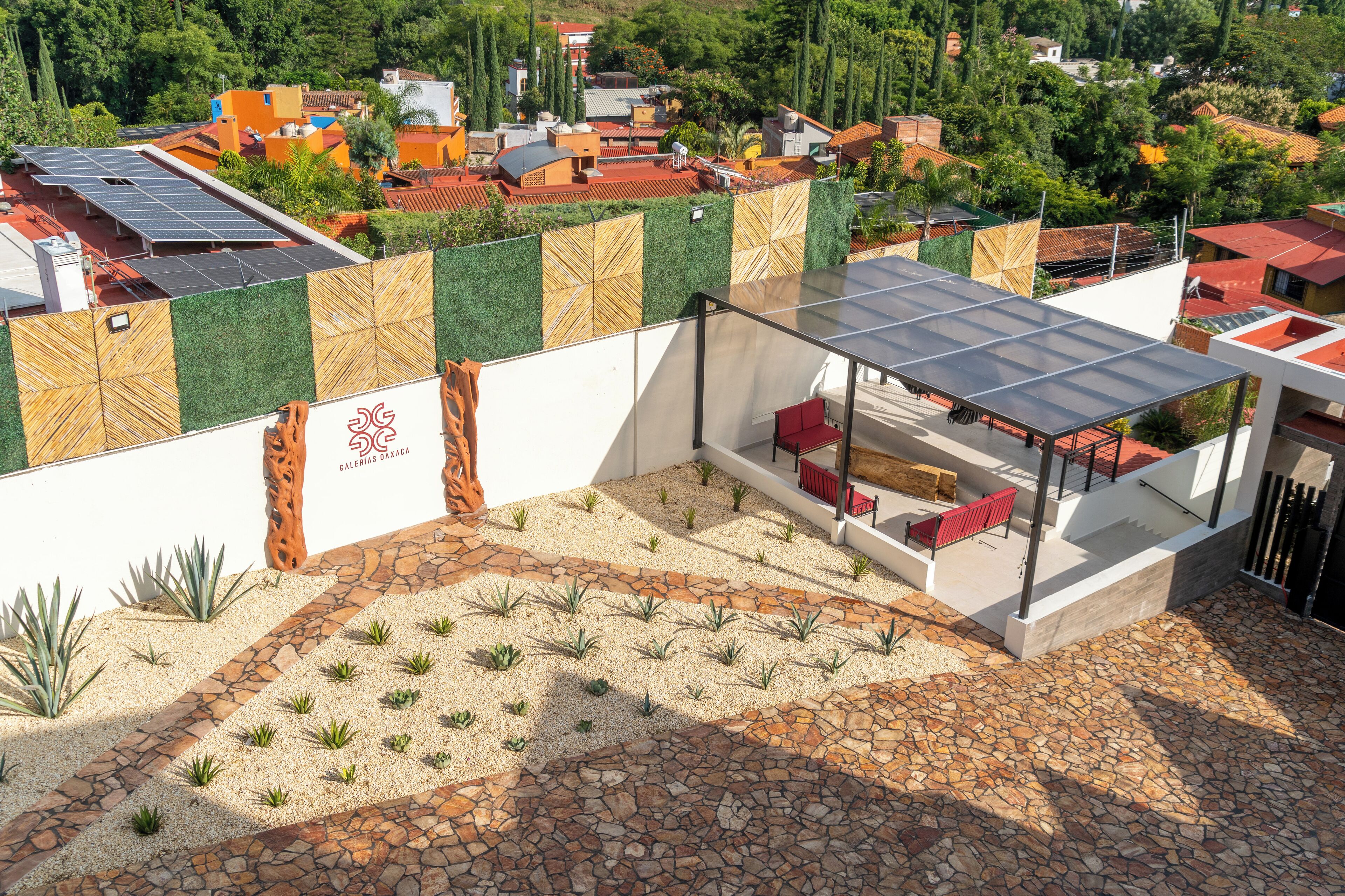 Une terrasse sur le toit, dotée d’une structure vitrée, de sièges et d’un mur décoratif orné d’un logo.