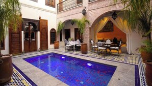A courtyard with a pool, outdoor seating, and traditional architecture. - Deluxe Double Room (Marrakech)