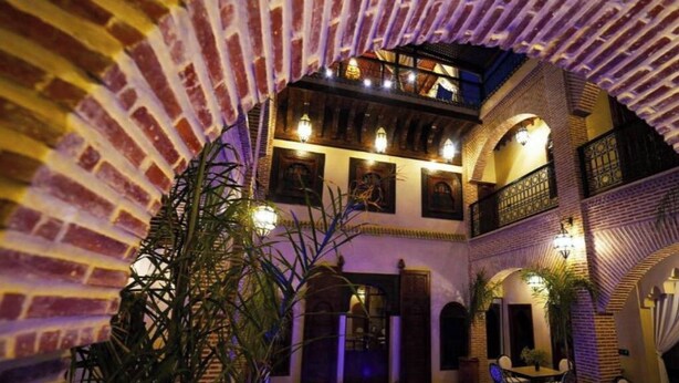 A courtyard with a pool, brick walls, and outdoor seating. - Deluxe Double Room (Marrakech)