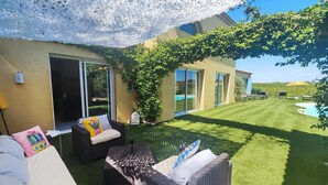 A patio with wicker furniture, a pool, and a house with large windows and a covered area. - Nice home in Usclas-d'Hérault (Usclas-d'Hérault)