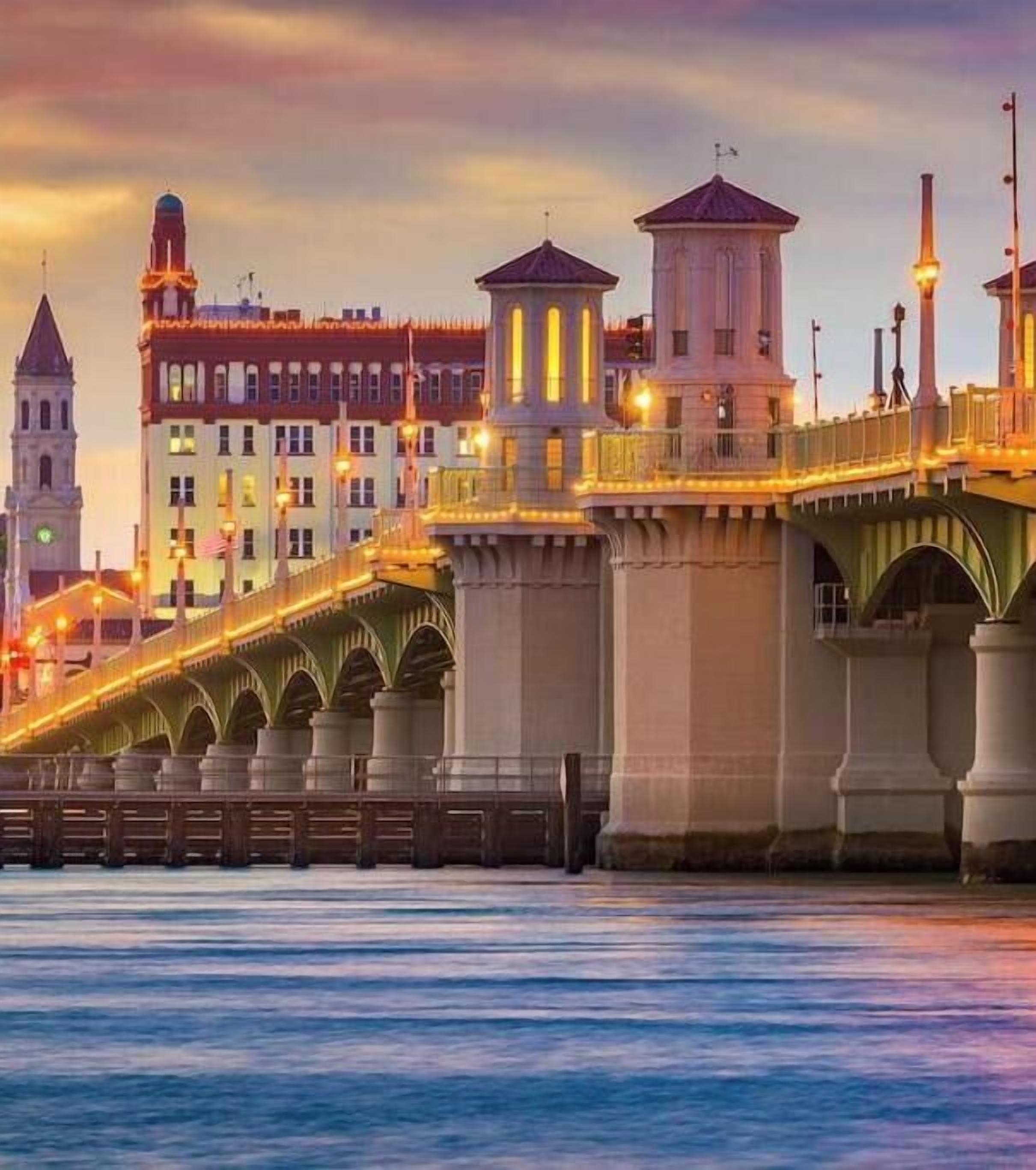 A bridge with multiple arches and a tower with a clock.
