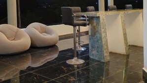 Ein modernes Interieur mit Marmorboden, einer Bar und Sitzgelegenheiten.