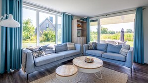 A modern living room with two sofas, a coffee table, and a bookshelf. - 3 bedroom amazing home in Kamperland (Kamperland)